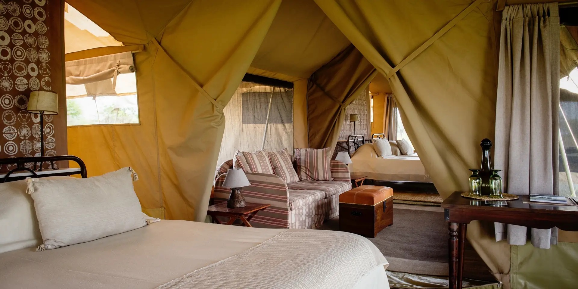 Interior of a luxury safari tent showing bed and decor